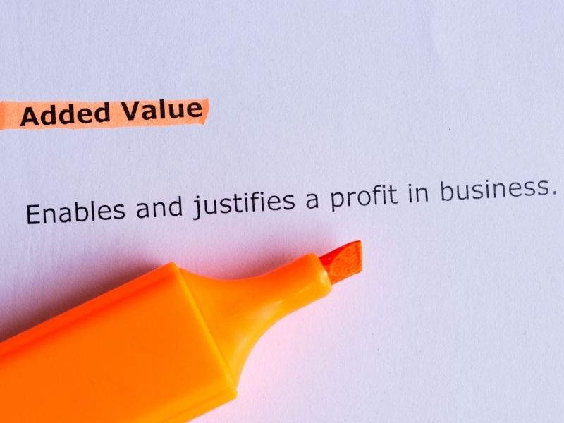 A marker highlighting the words 'Added value' on a white page.